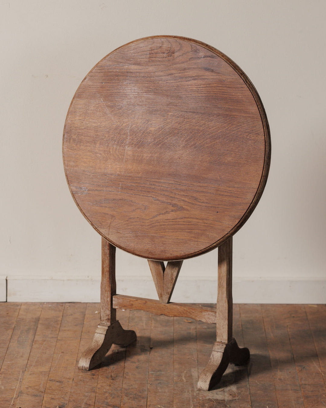 Antique round wooden tilt-top table.