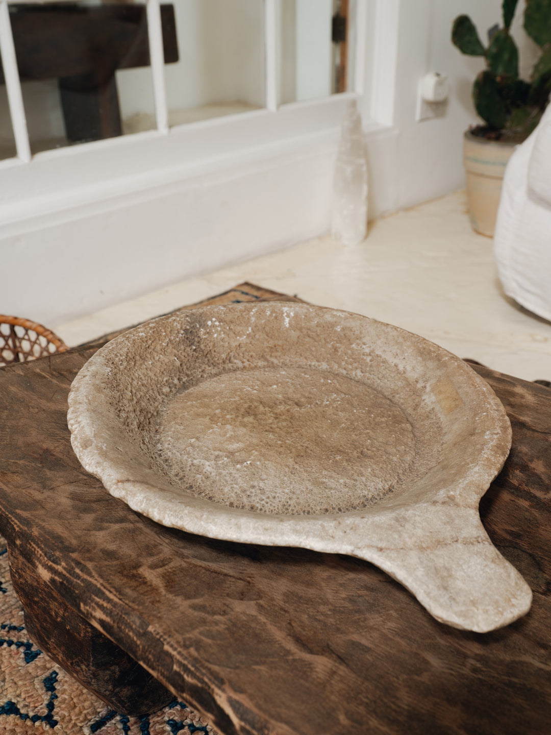 a plate with a handle is sitting on a wooden table .