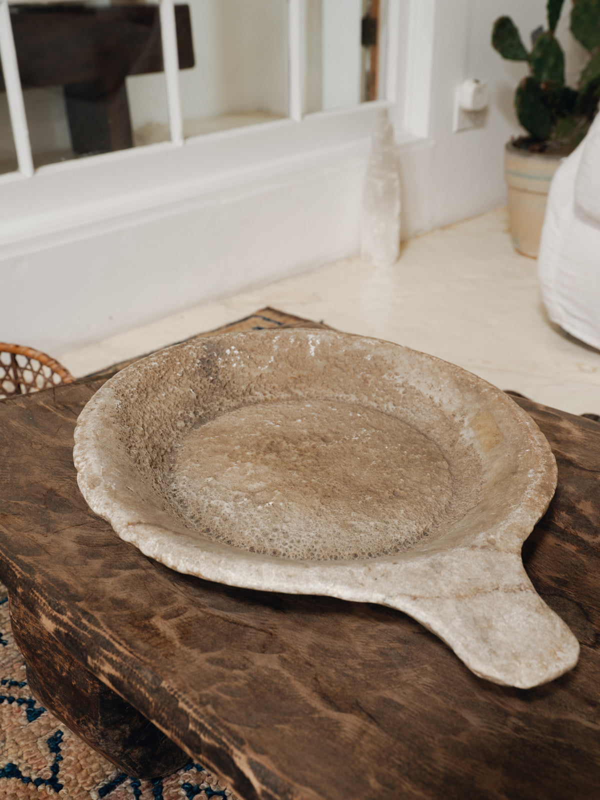 a plate with a handle is sitting on a wooden table .