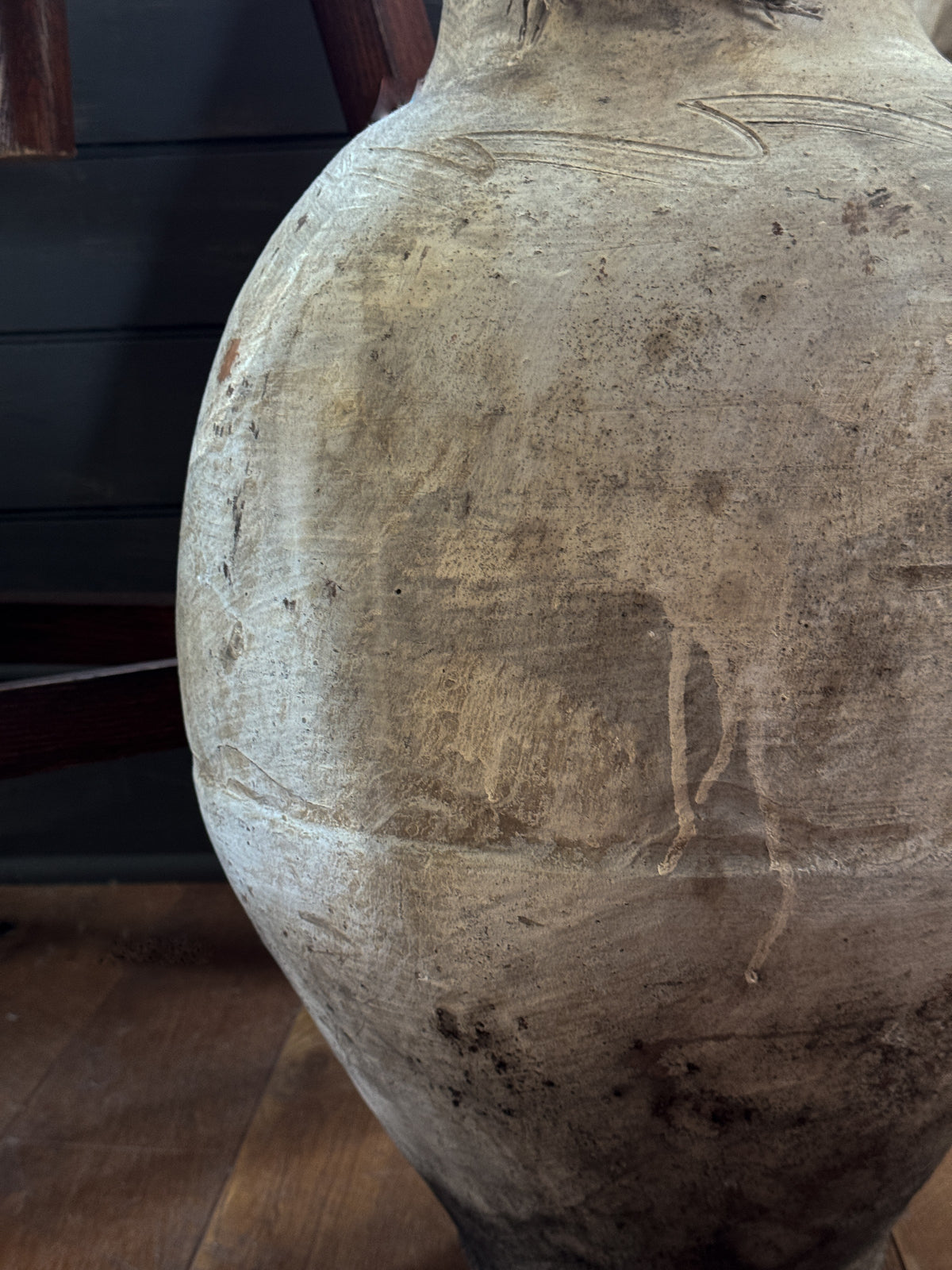 a large white vase is sitting on a wooden floor