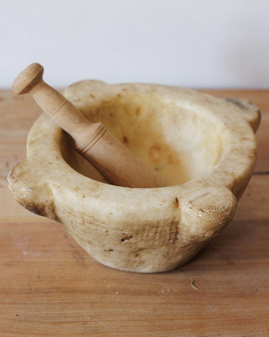 An aged stone mortar with a wooden pestle.