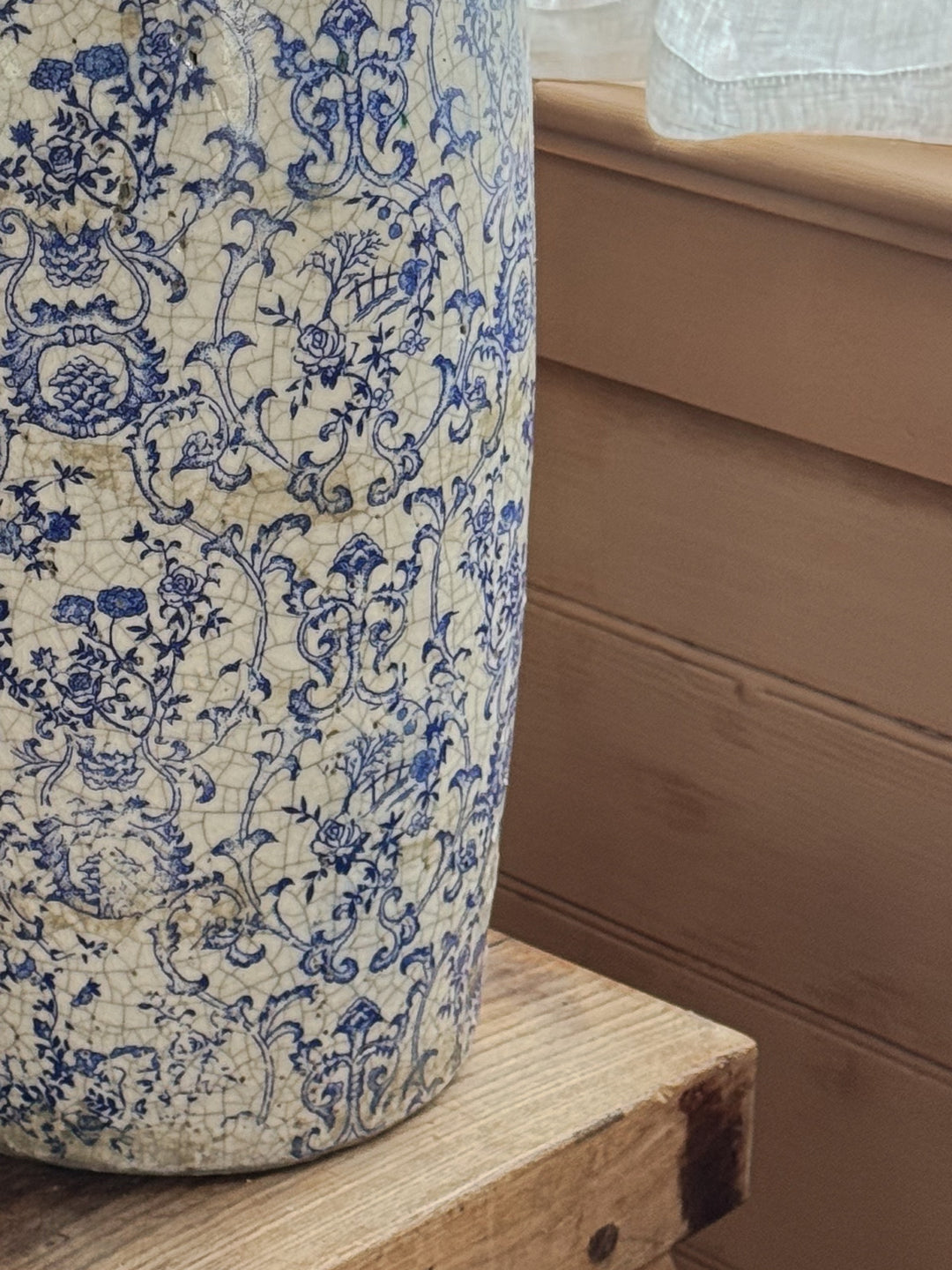 a blue and white vase sits on a wooden table