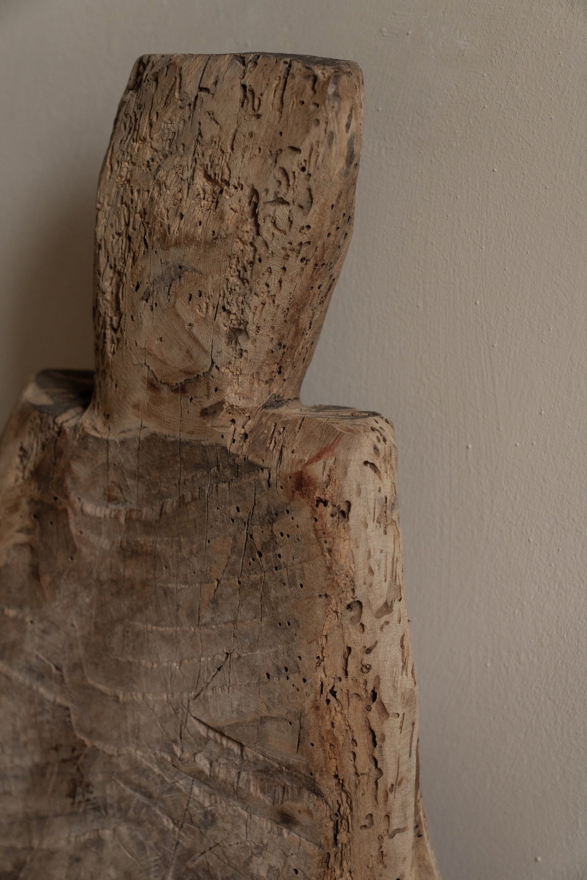 a close up of a wooden sculpture against a white wall .