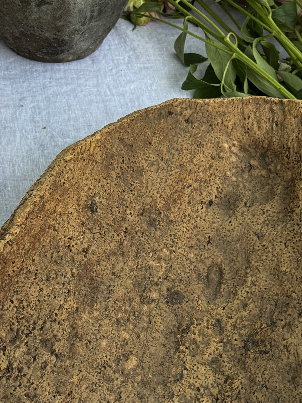 a close up of a piece of wood on a table with flowers in the background .