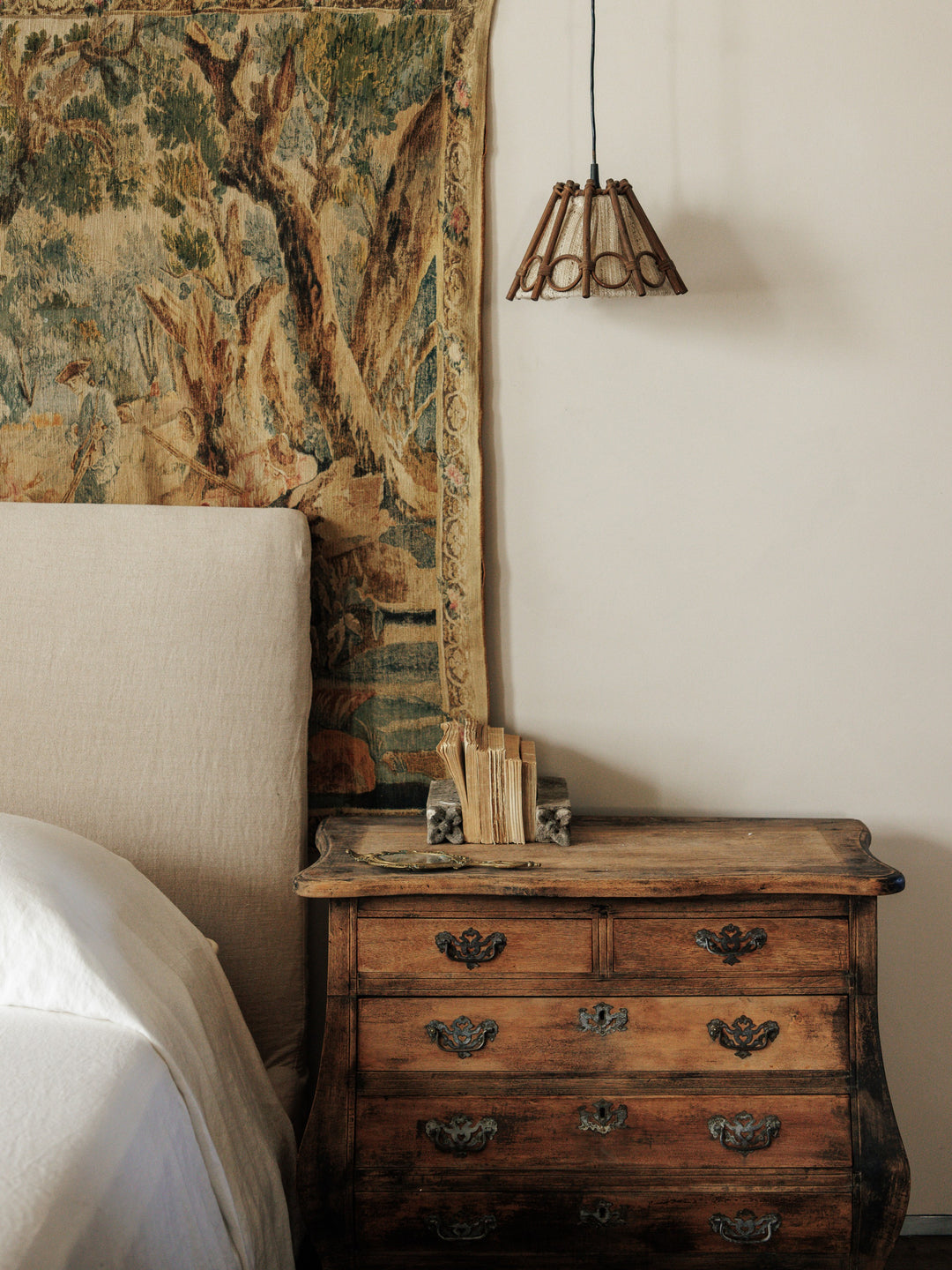 a bedroom with a dresser and a tapestry on the wall