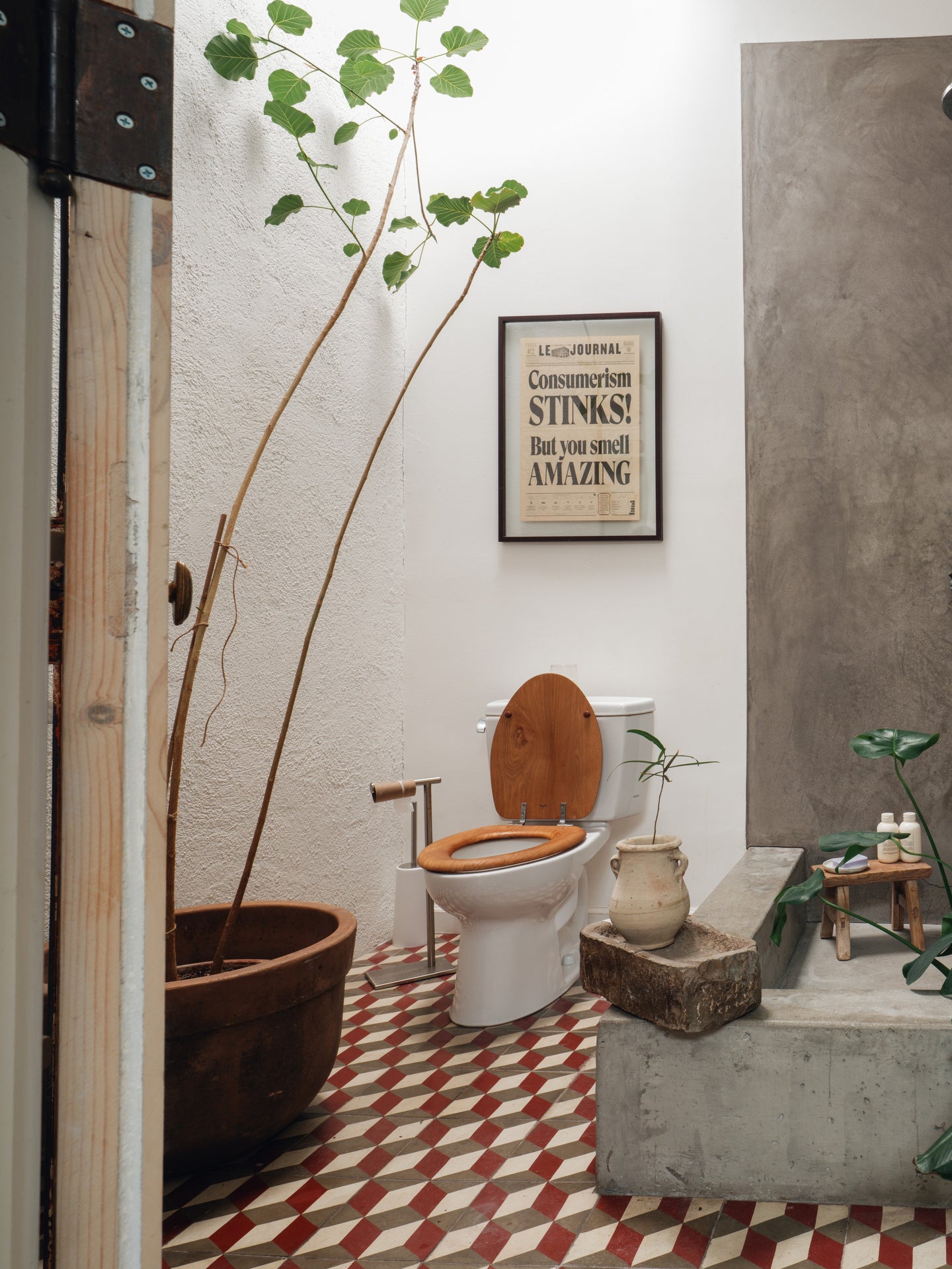 a bathroom with a sign on the wall that says consumerism stinks but you smell amazing