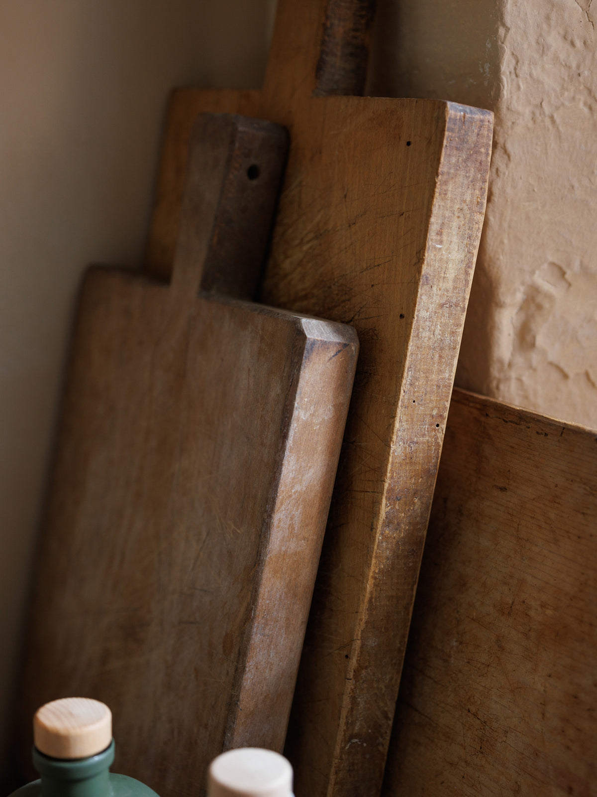 three wooden cutting boards are stacked on top of each other on a table .