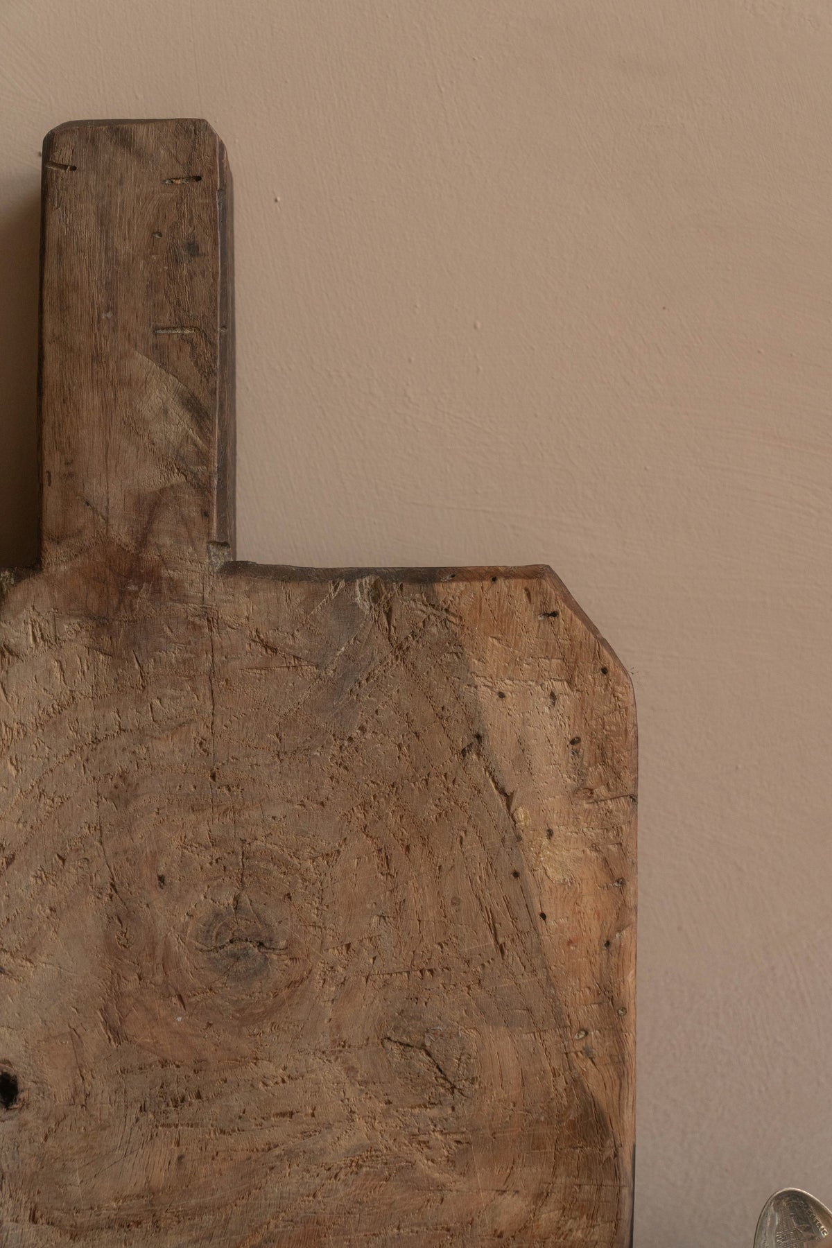 a wooden cutting board is sitting on a table next to a spoon .