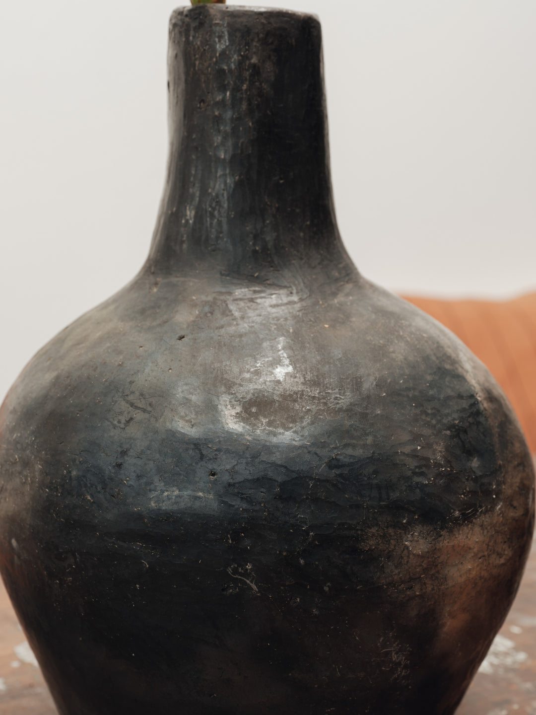 a black vase is sitting on a wooden table