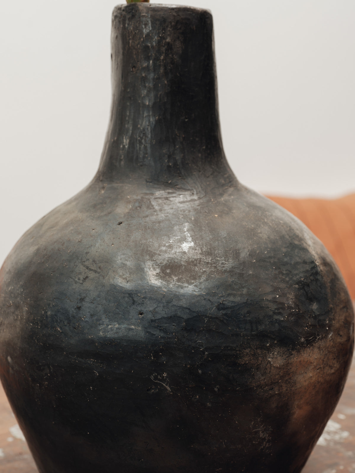 a black vase is sitting on a wooden table