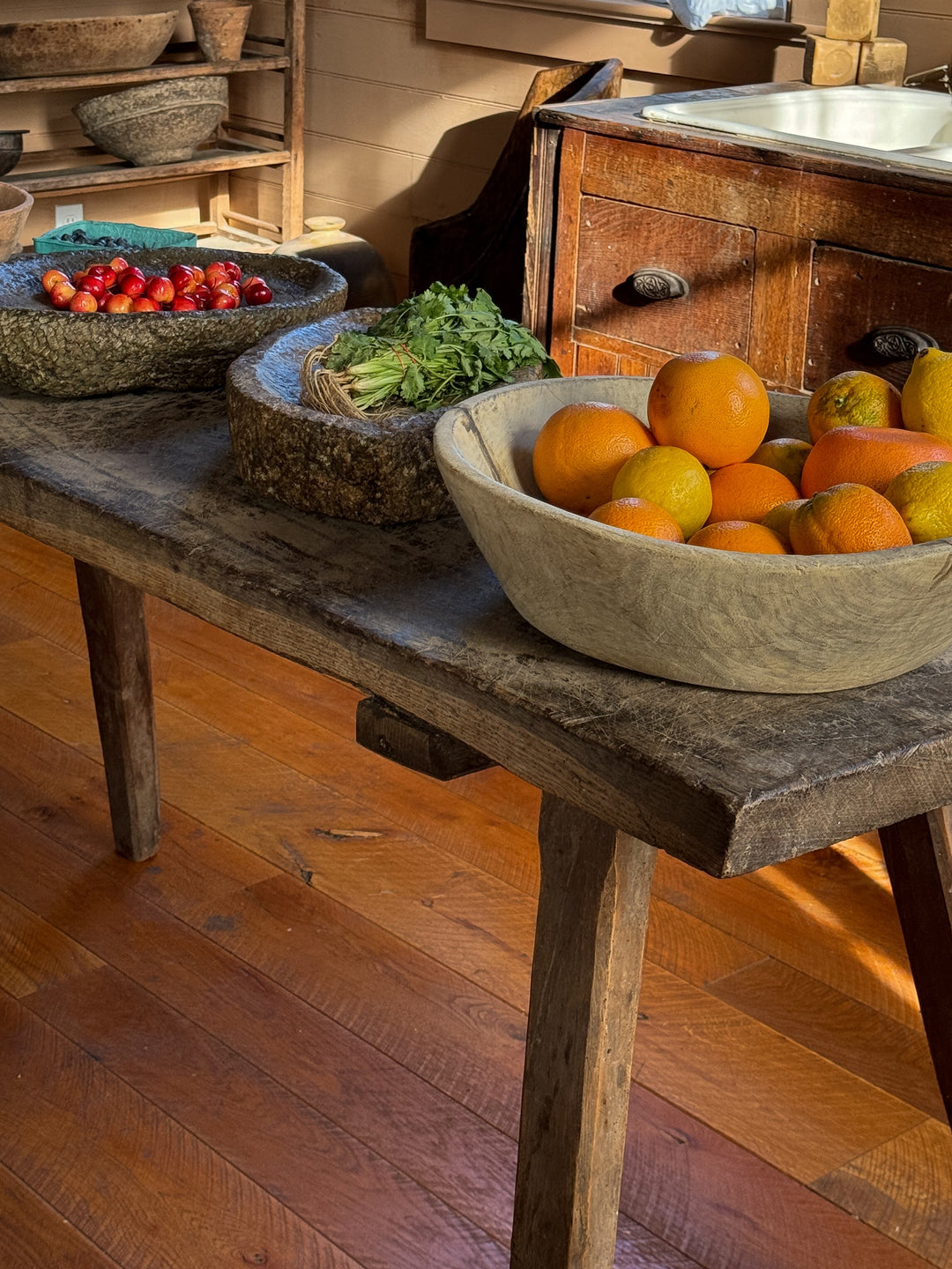 a wooden table with bowls of fruit and vegetables on it .