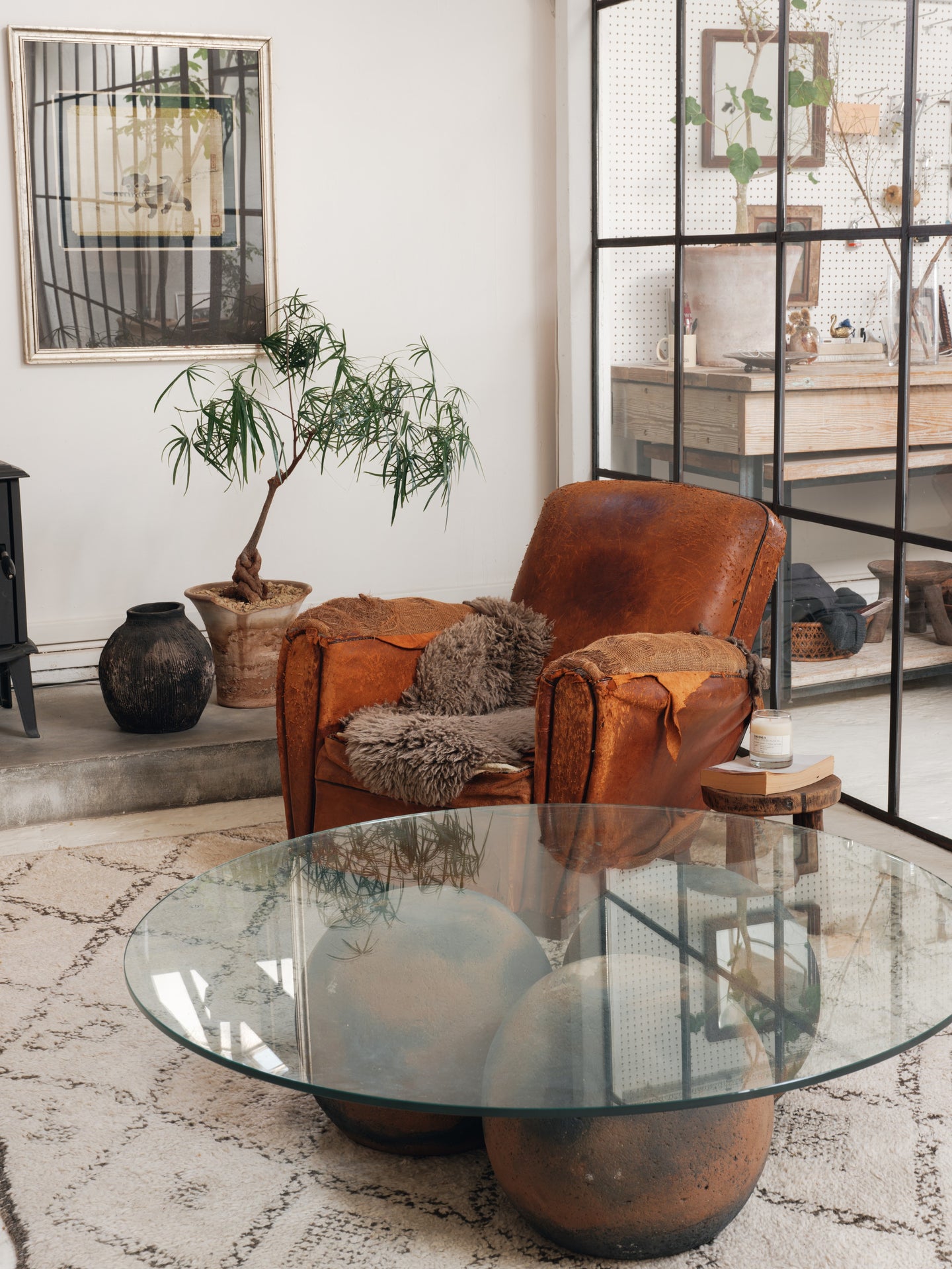a living room with a brown leather chair and a glass coffee table .
