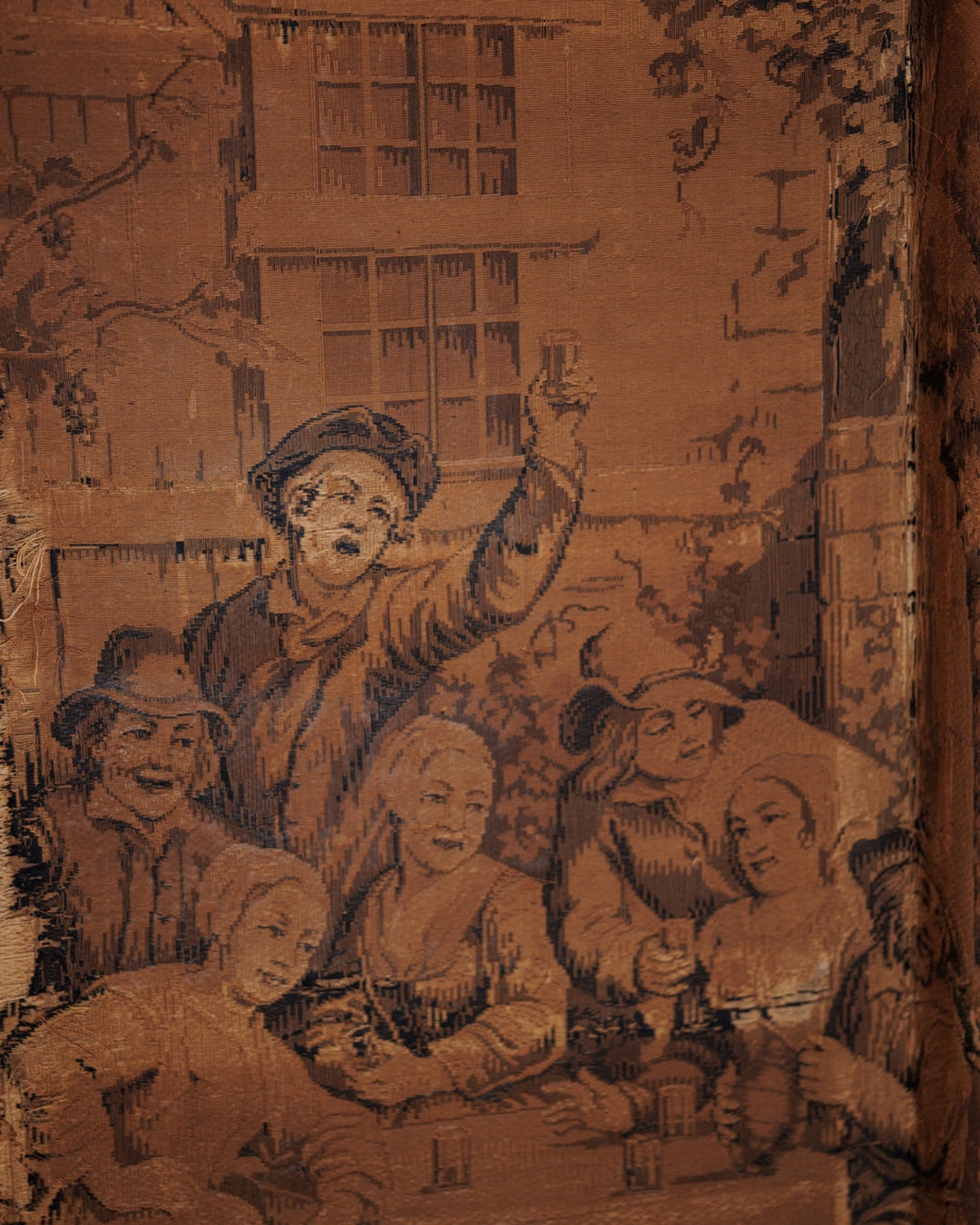 Woven tapestry in sepia tones showing a group of historical figures toasting and drinking at a table outdoors.