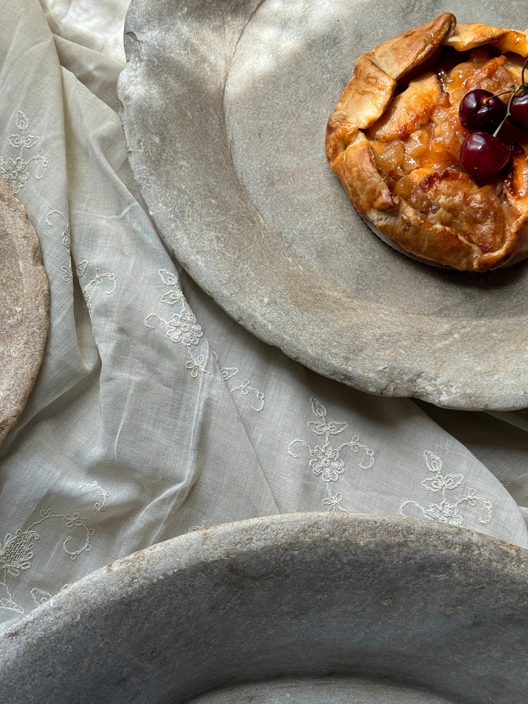 a pie with cherries on top of it sits on a plate