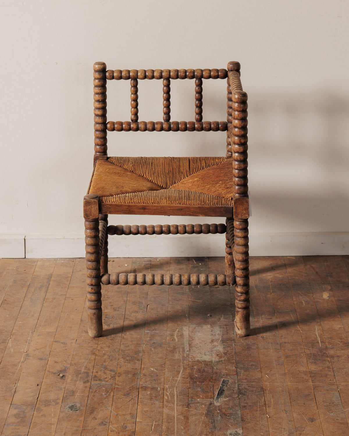 Rustic bobbin turned wood chair with a woven rush seat.