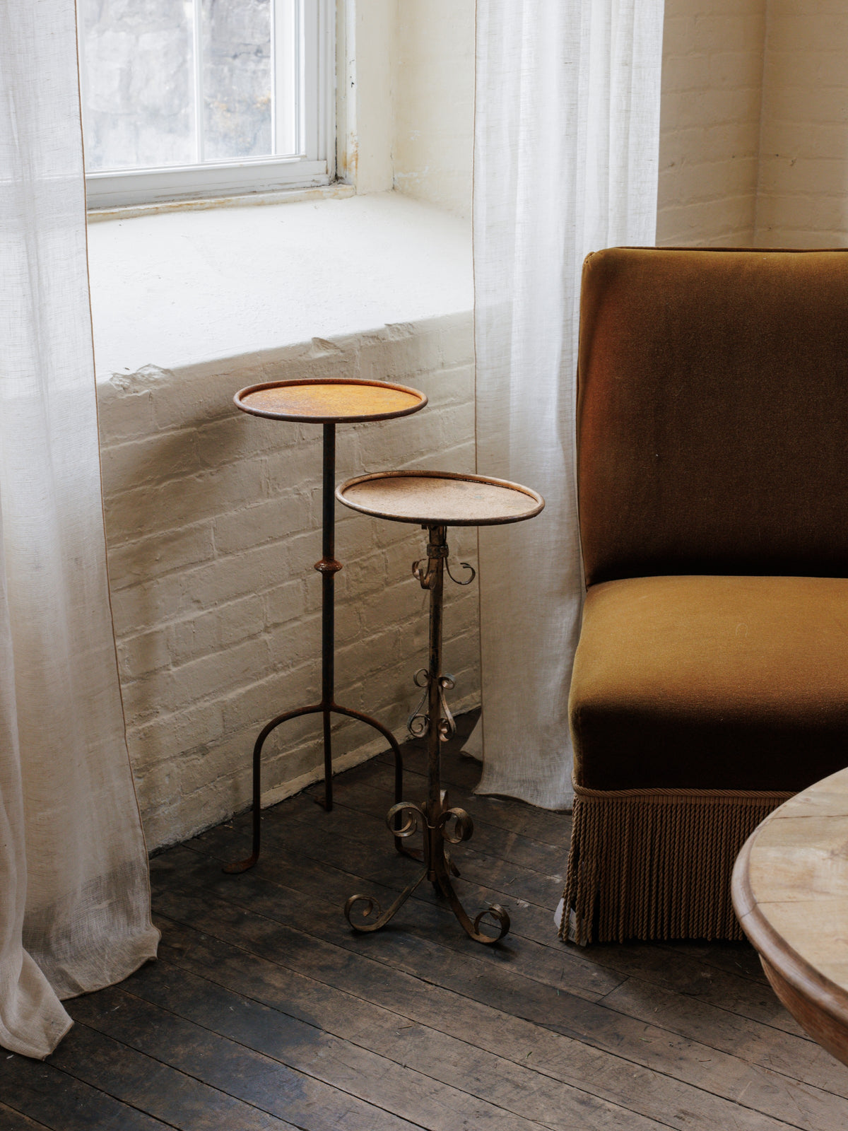 a chair is sitting next to a table in front of a window .