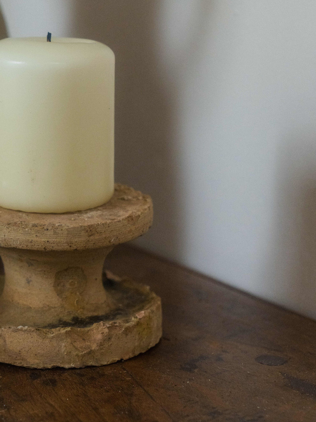 a white candle is sitting on top of a wooden table .