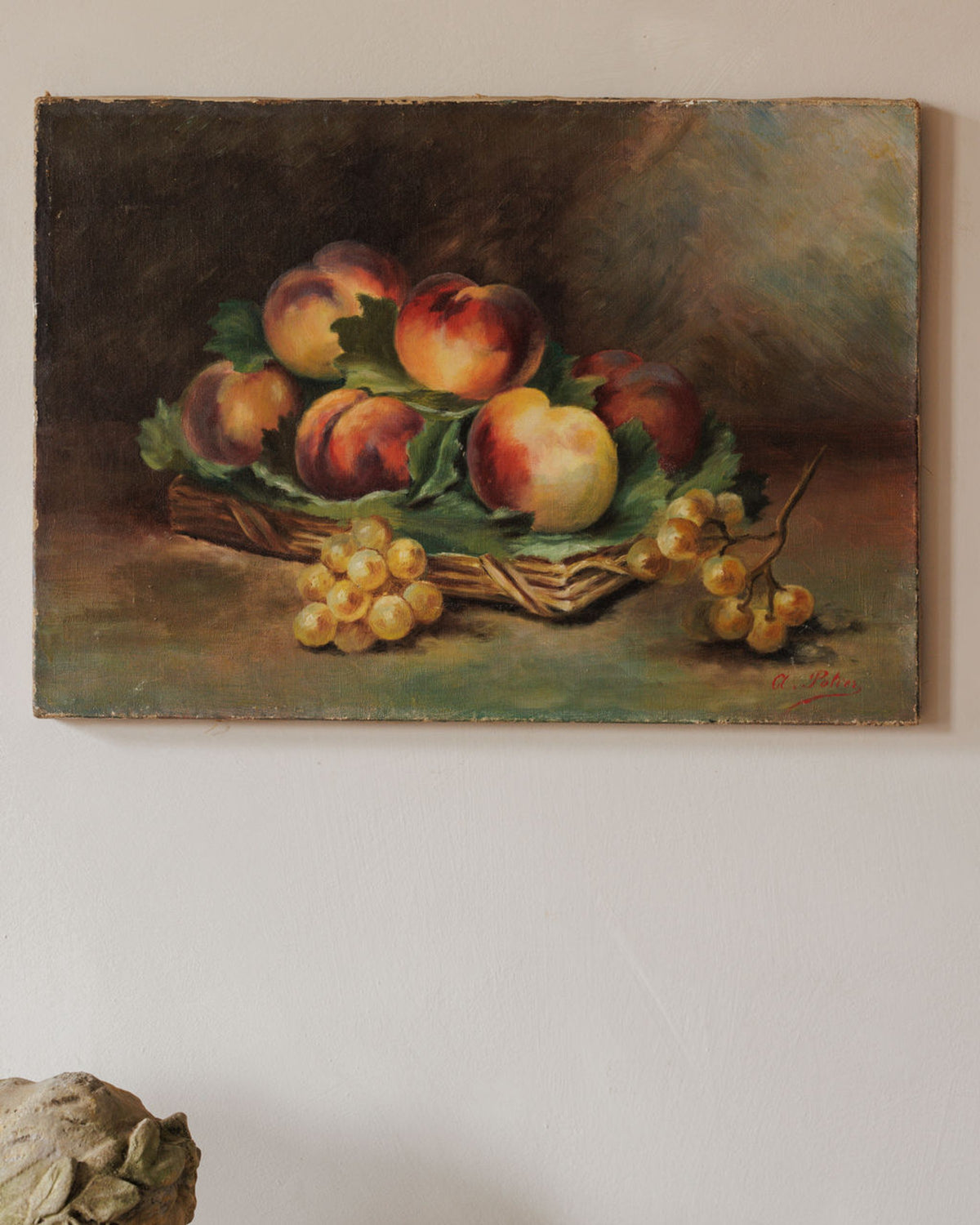 An oil painting of a still life with peaches in a basket and bunches of grapes.