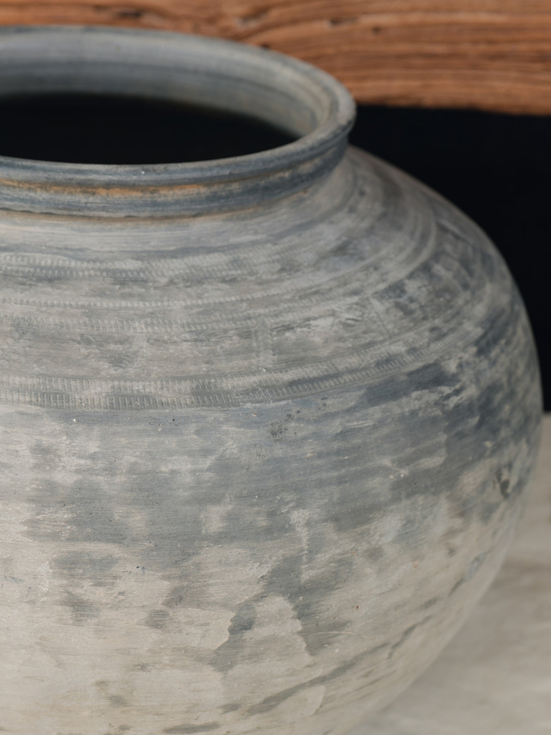 a large gray vase is sitting on a table .