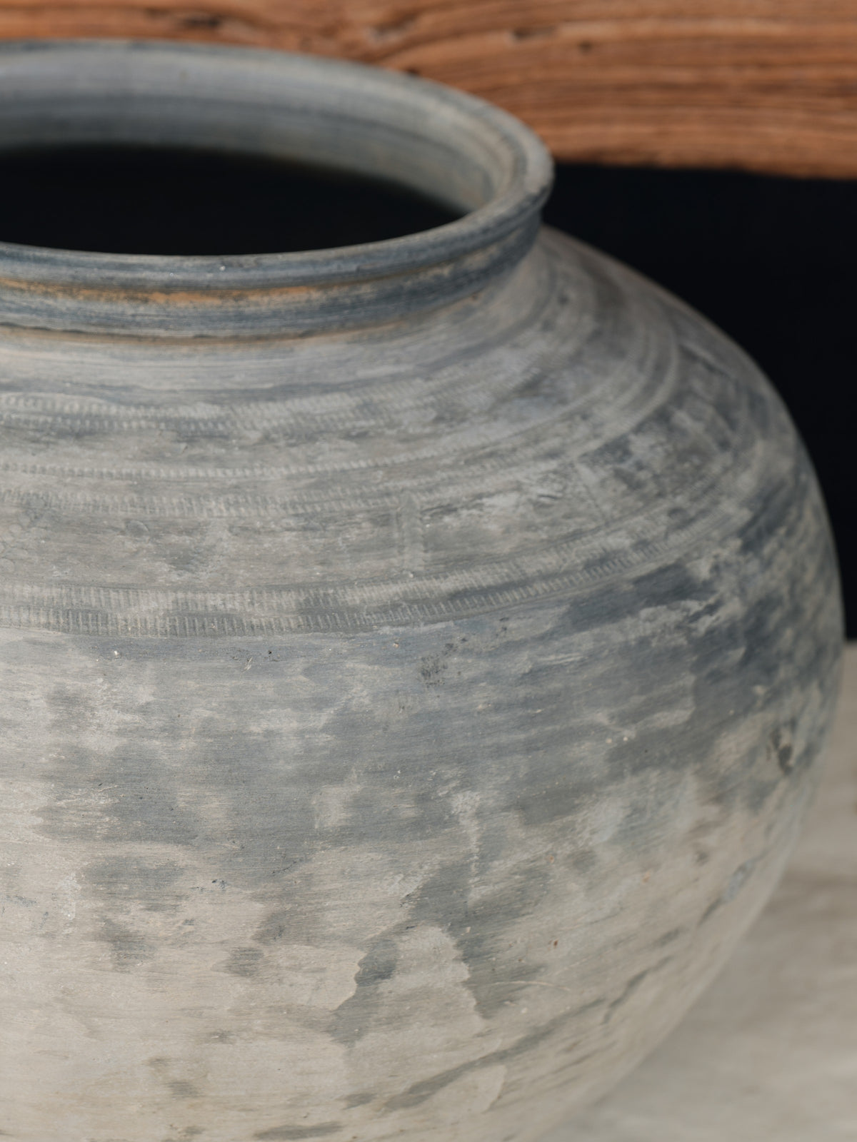 a large gray vase is sitting on a table .