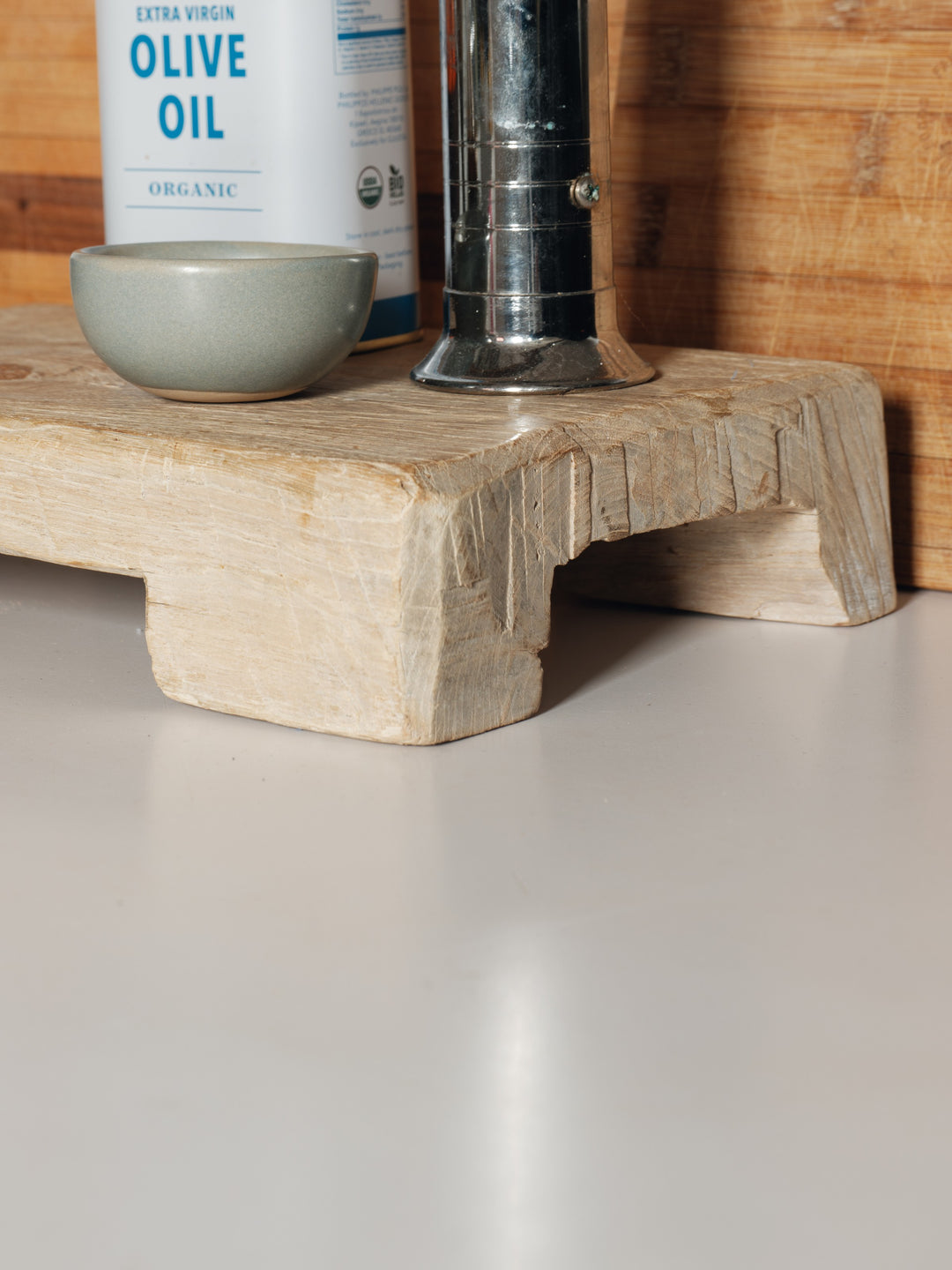 a bottle of extra virgin olive oil sits on a wooden cutting board