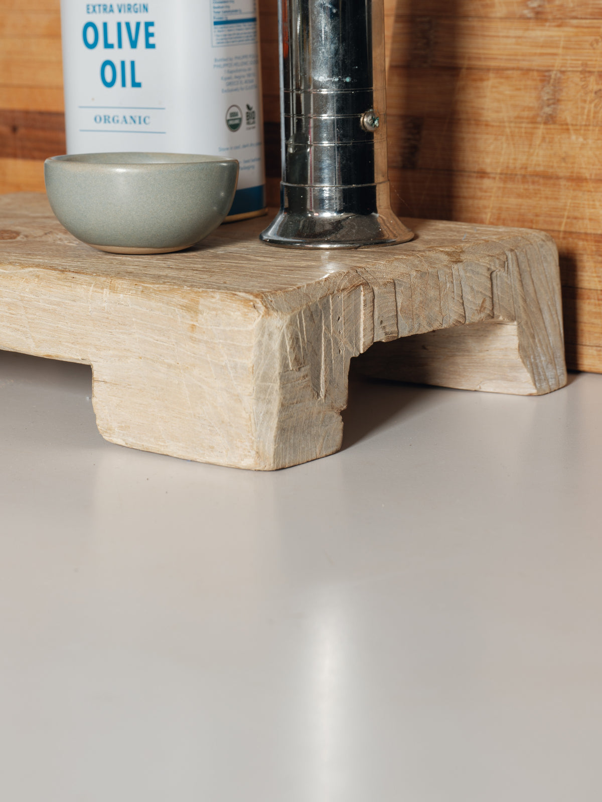 a bottle of extra virgin olive oil sits on a wooden cutting board
