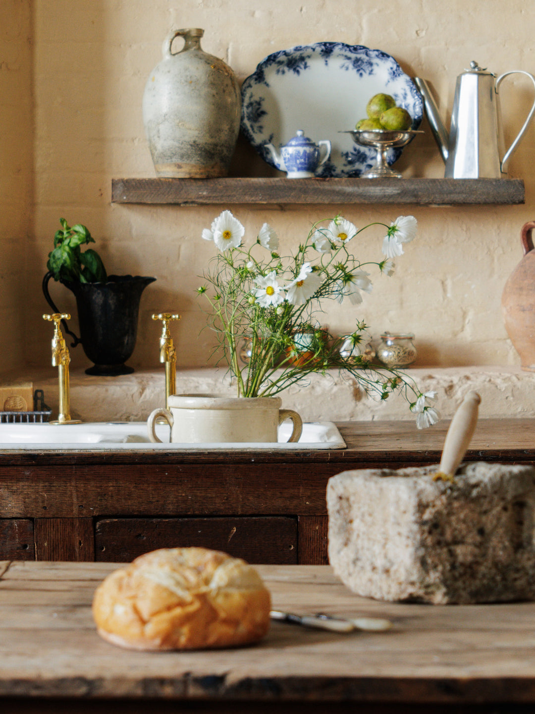 a kitchen sink with a vase of flowers in it