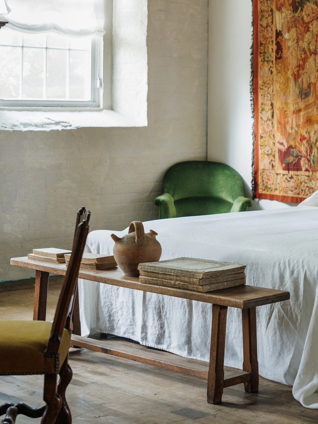 a french oak bench in a bedroom next to a bed