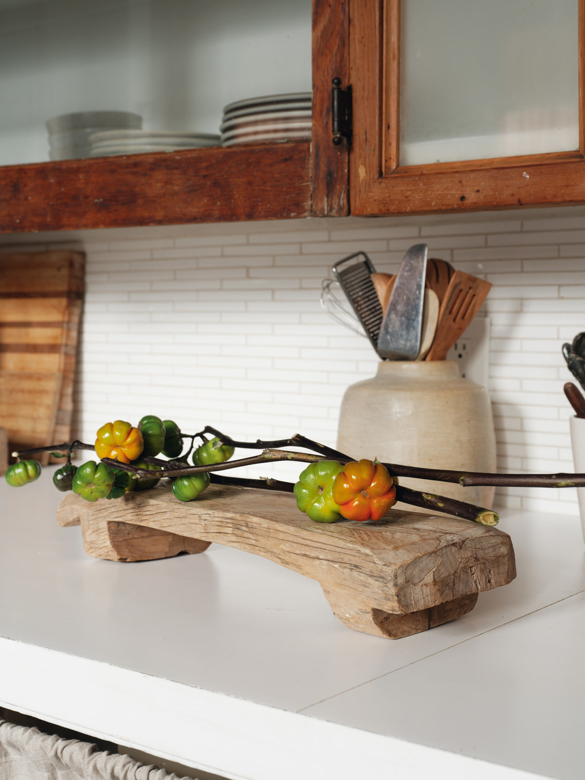 a wooden cutting board with tomatoes on it in a kitchen