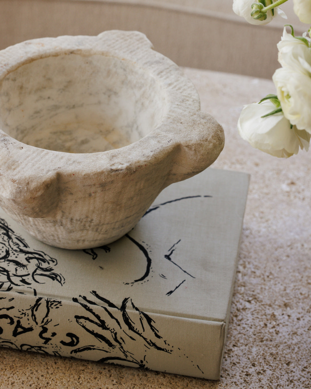 a stone bowl is sitting on top of a book on a table .