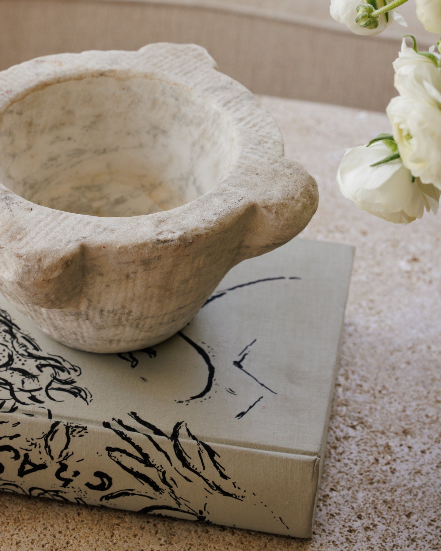 a stone bowl is sitting on top of a book on a table .