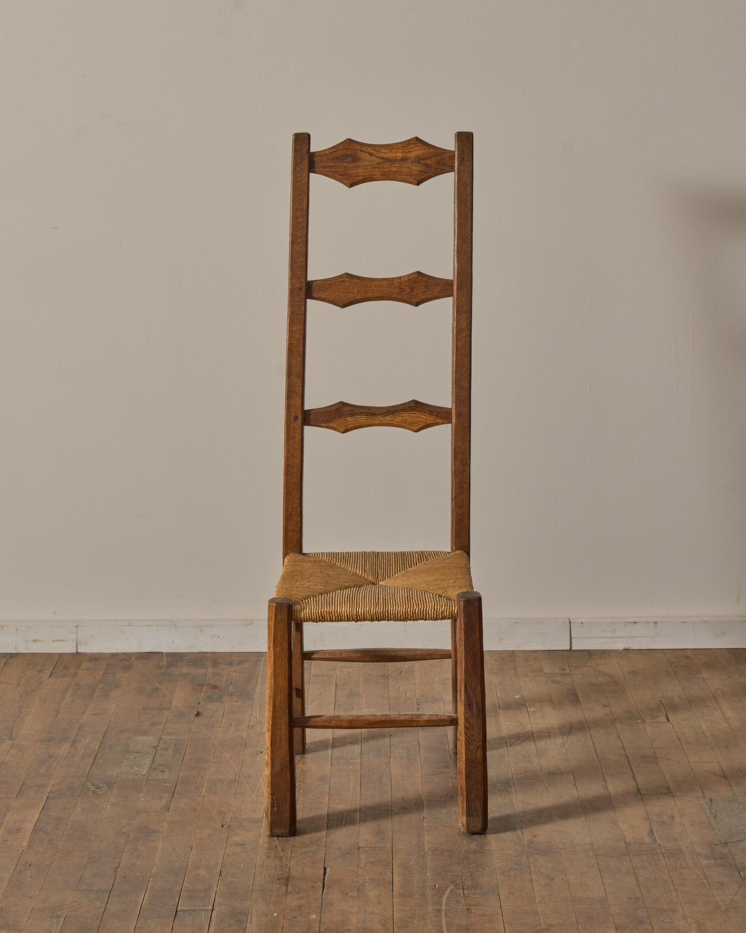 Rustic wooden chair with woven rush seat and three decorative back slats.