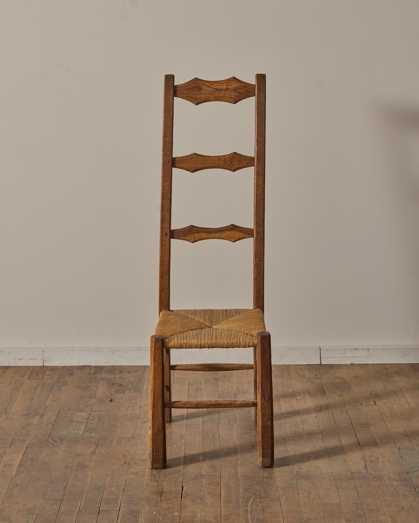 Rustic wooden chair with woven rush seat and three decorative back slats.