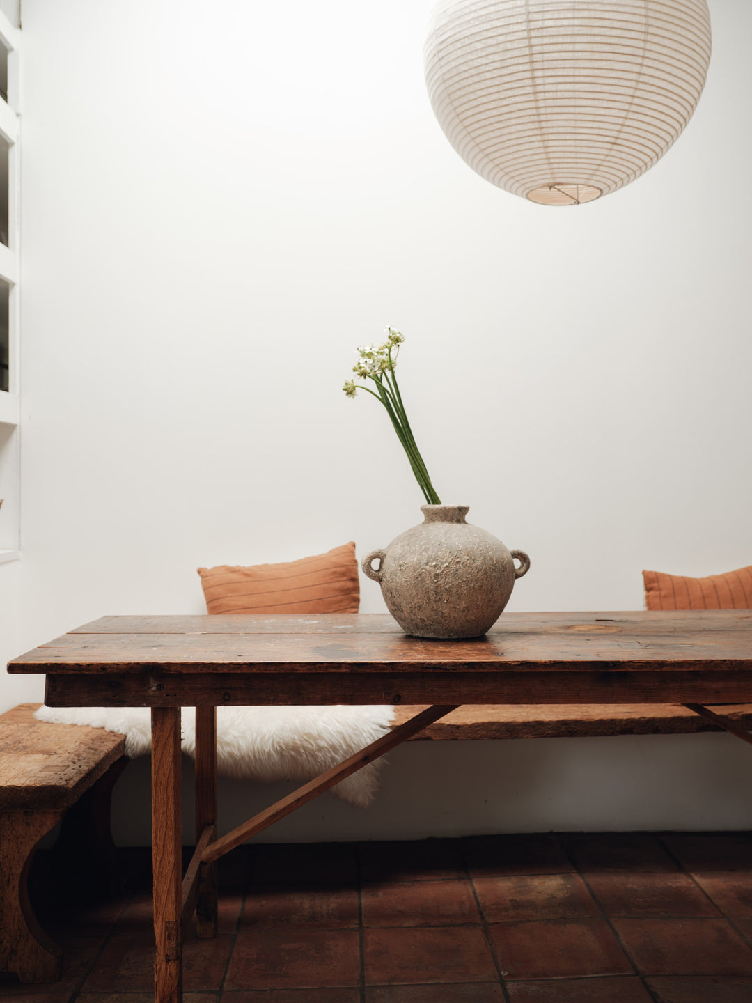 a vase with flowers in it is sitting on a wooden table .