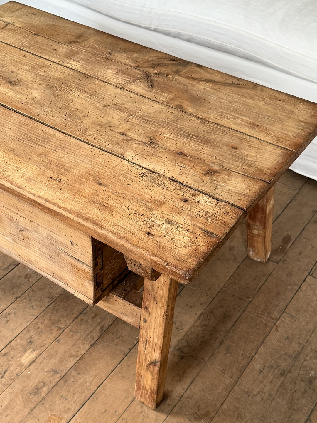 a wooden table is sitting on a wooden floor next to a white couch .
