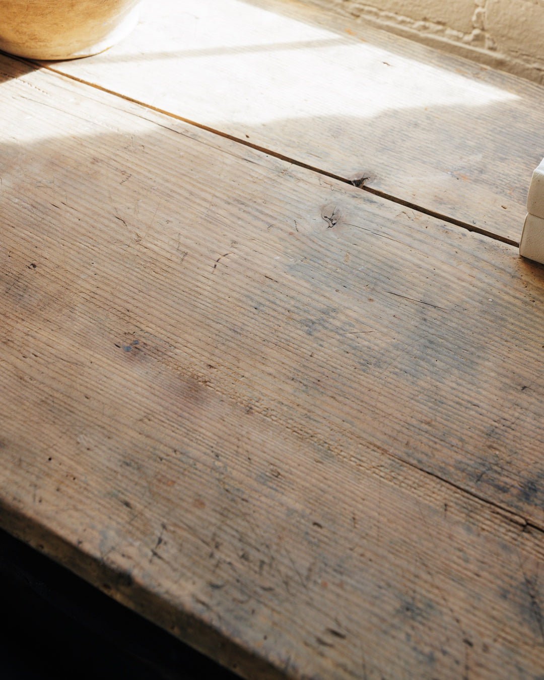 a wooden table with a bowl and a book on it .