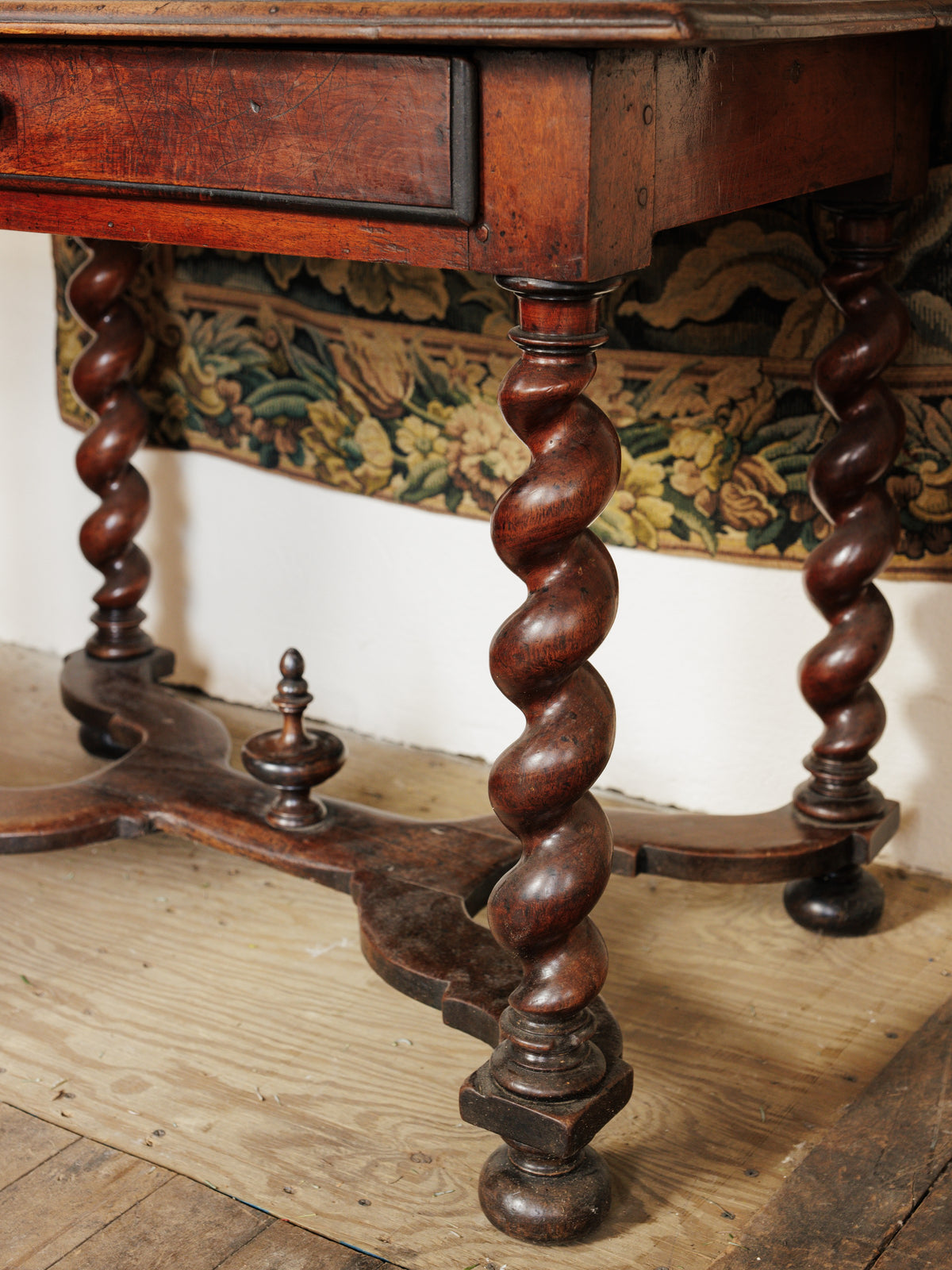 a wooden table with twisted legs and a drawer