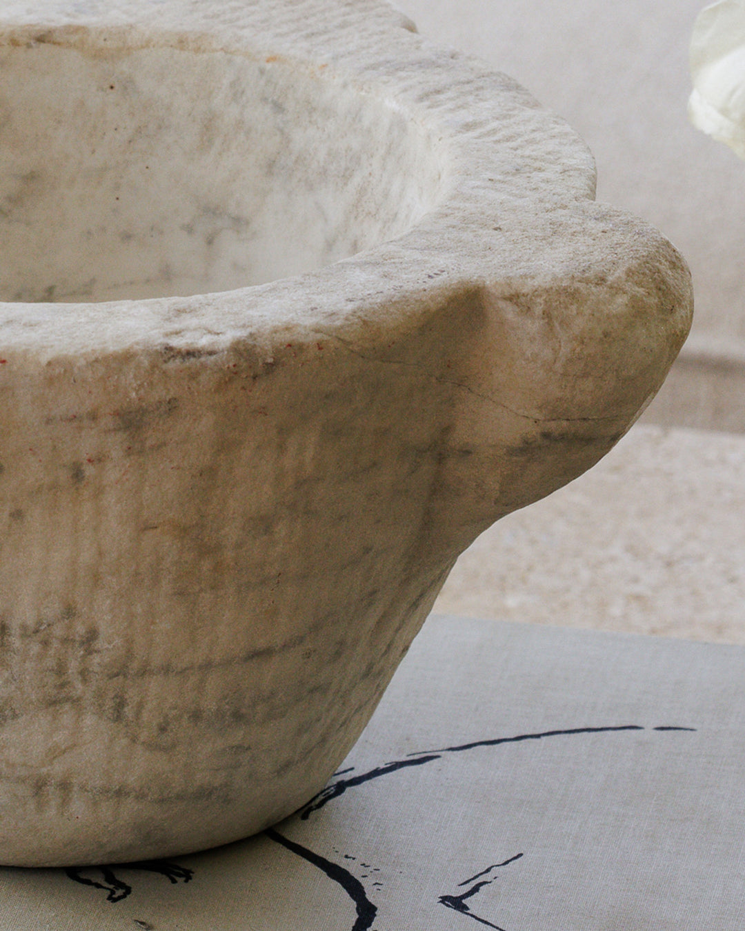 a white bowl with a handle is sitting on a table .