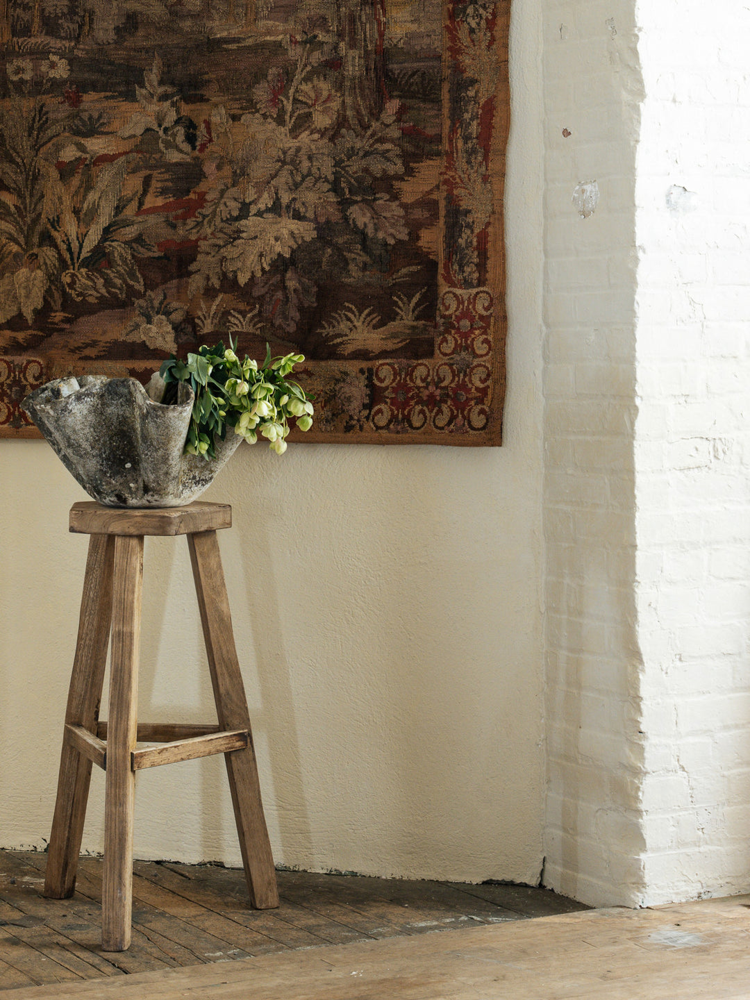 a wooden stool with a bowl of flowers on it