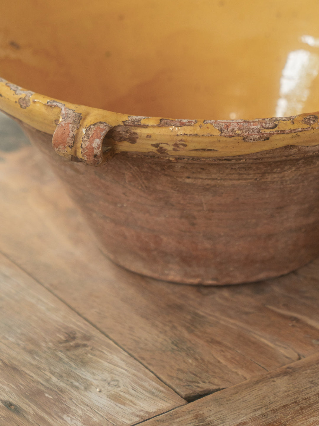 a large yellow bowl is sitting on a wooden table .