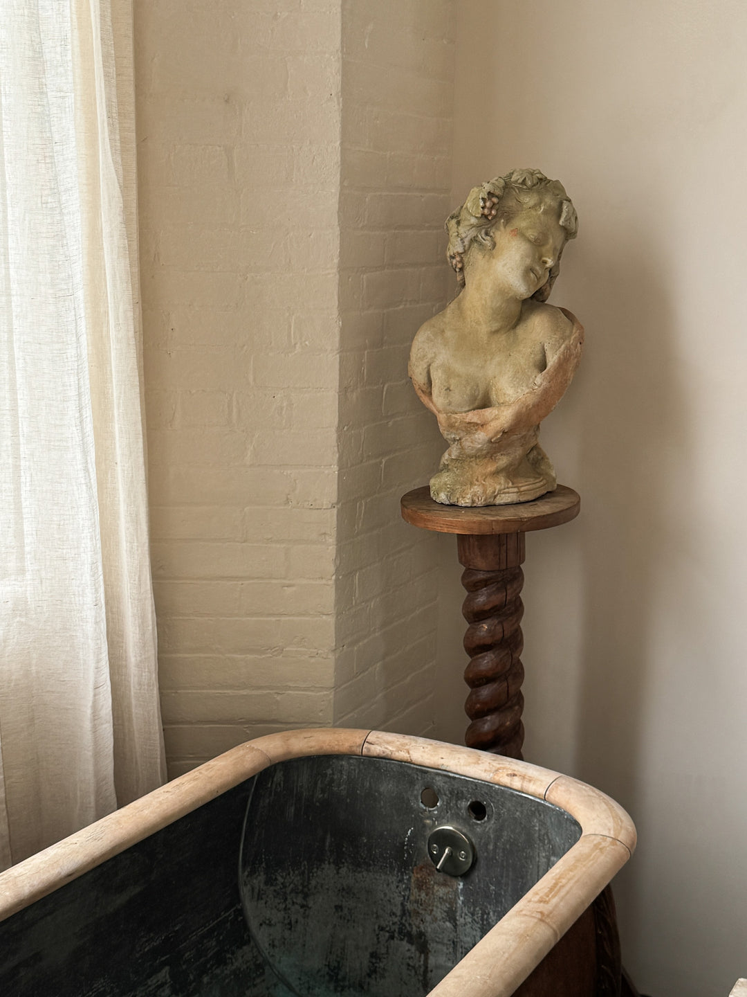 a statue of a woman sitting next to a bathtub