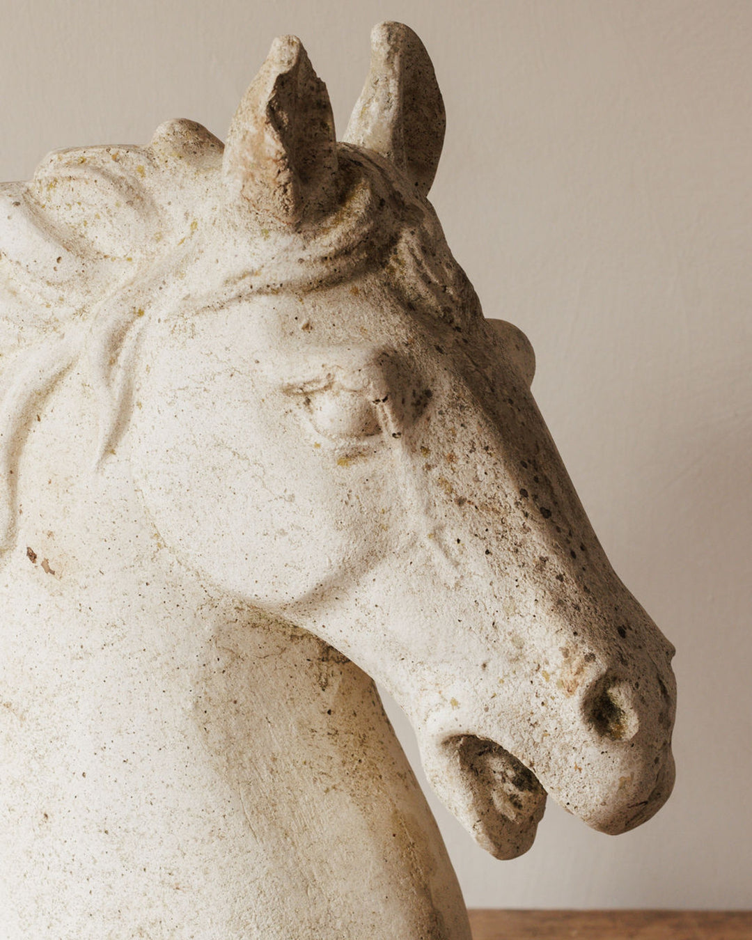 Weathered white horse head sculpture.