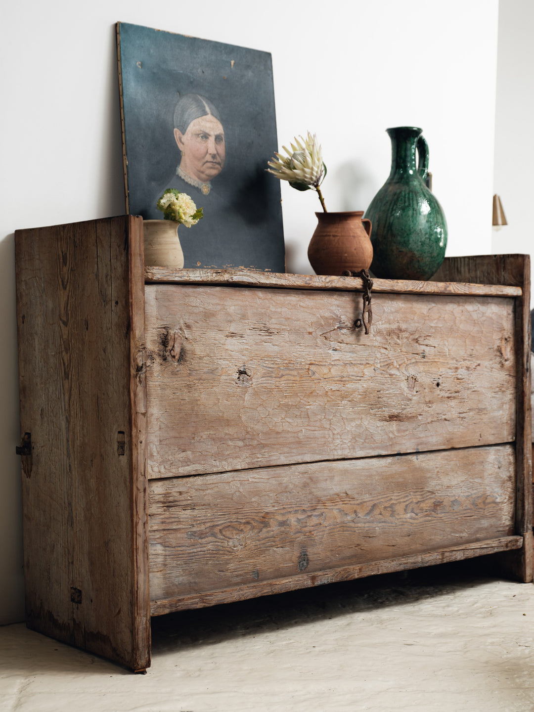 a wooden chest with a painting of a woman on top of it