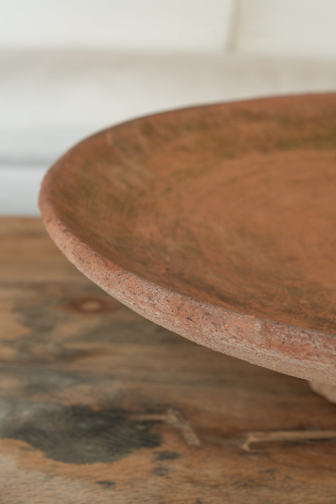 a close up of a clay plate on a wooden table .