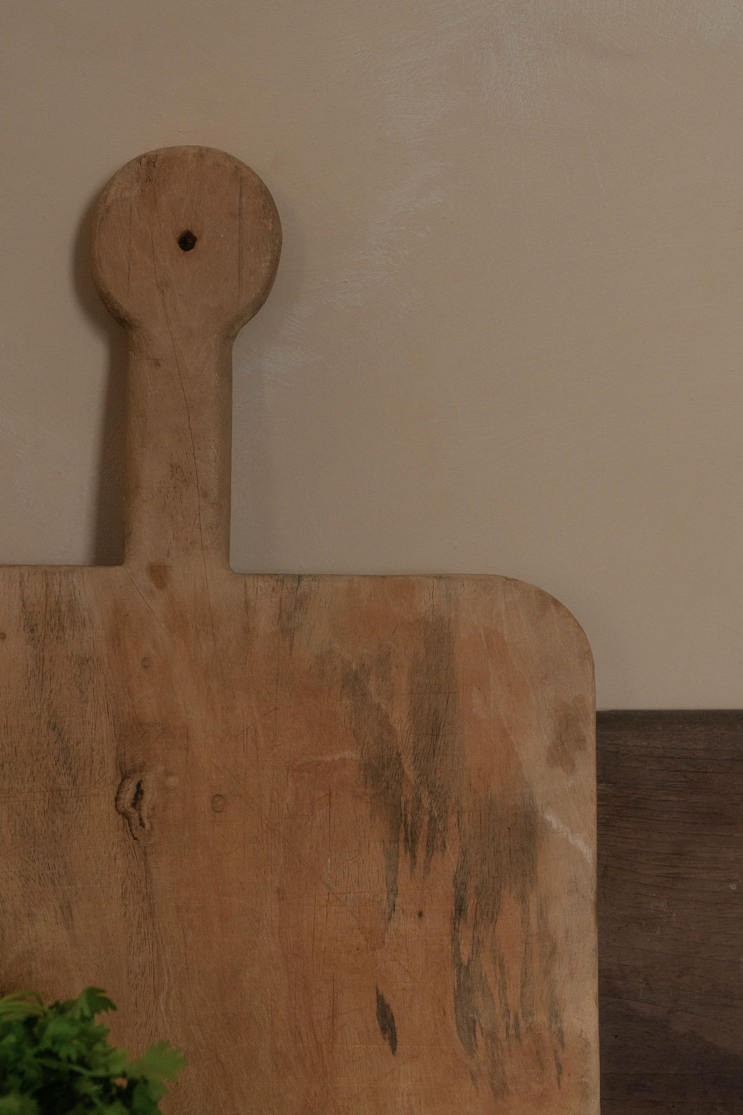 a wooden cutting board with a handle is sitting on a table .