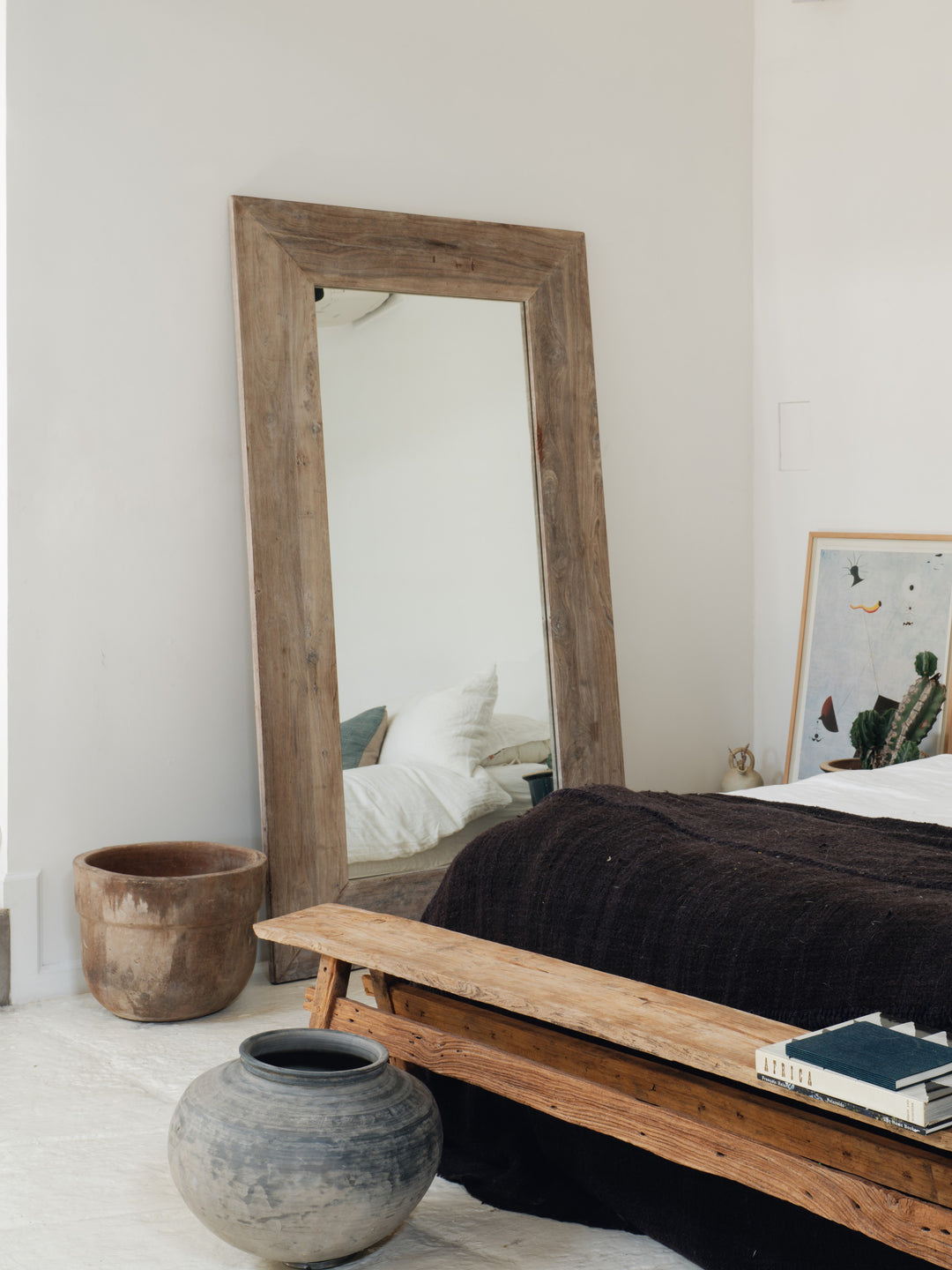 a full length mirror in a bedroom next to a bed