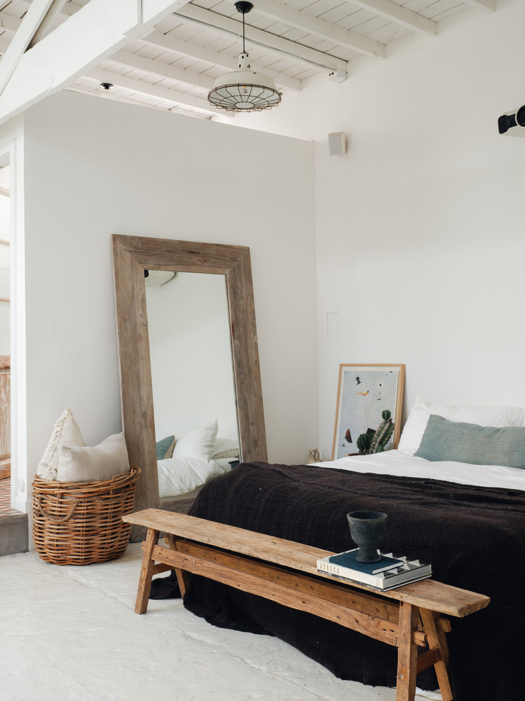 a bedroom with a large mirror and a wooden bench