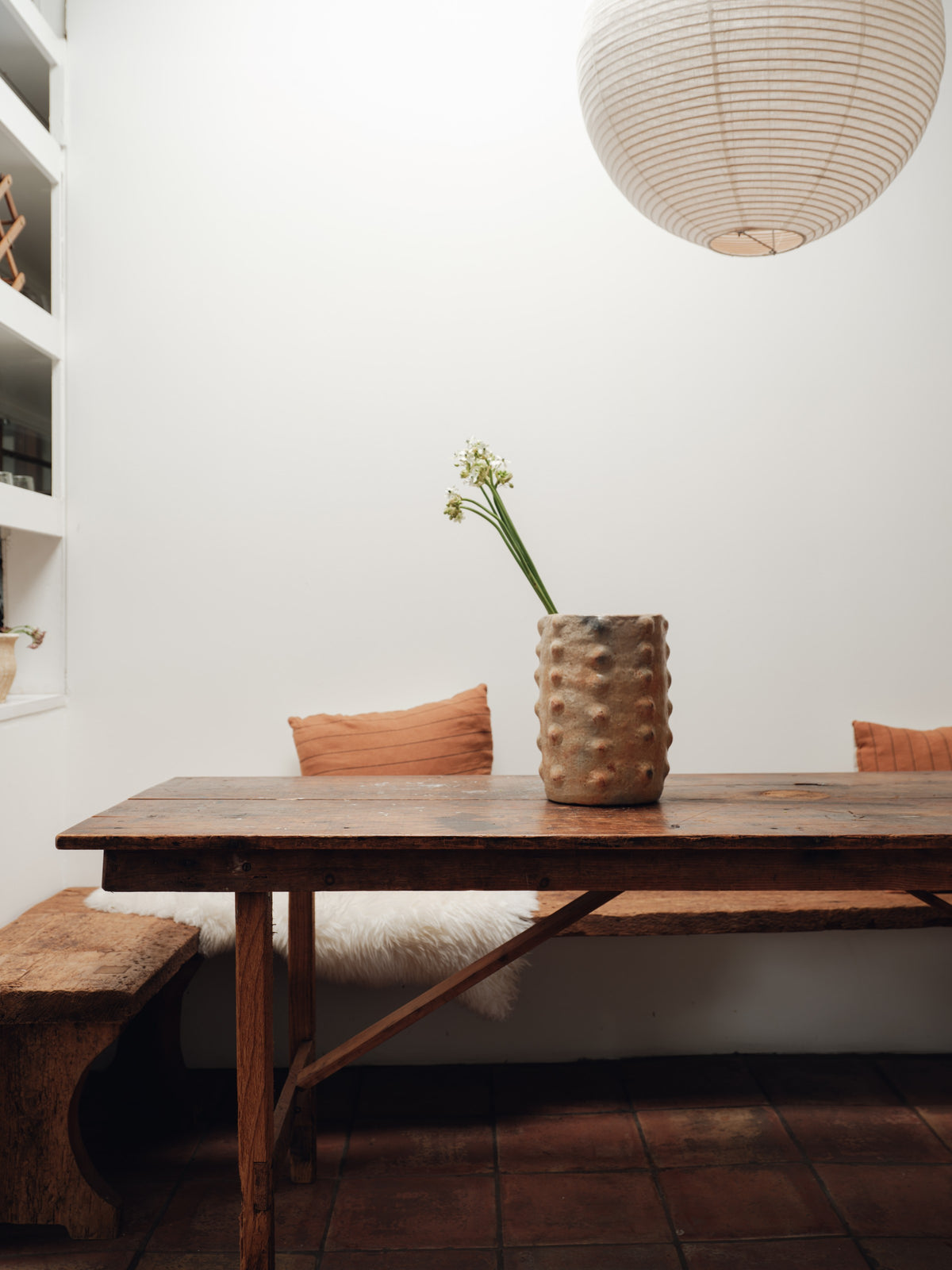 a wooden table with a vase of flowers on it in a dining room .