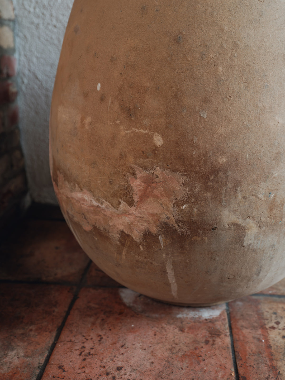 a large brown vase is sitting on a tiled floor