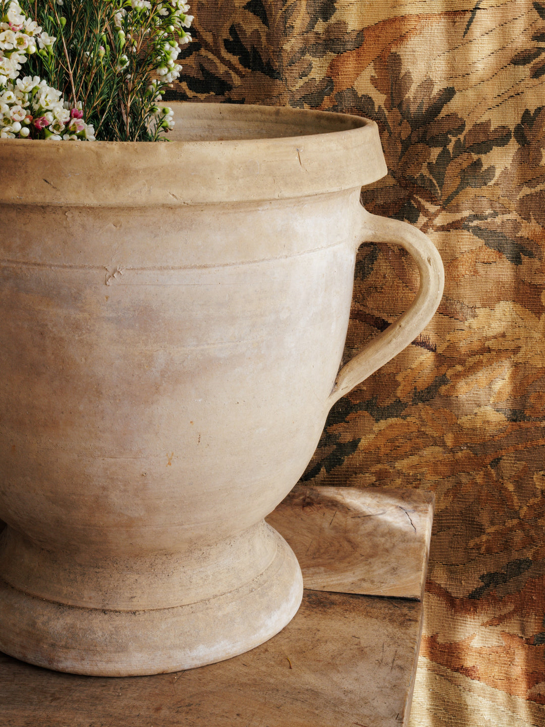 a large pot with flowers in it is sitting on a table .
